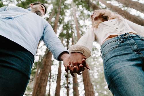 holding hands shalow focus photo of man and woman holding each others hands person